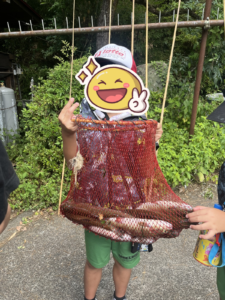 子供が魚を持ち上げている写真