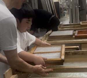 紙漉き体験をする小学生
