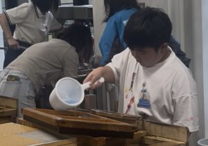 いの町紙の博物館で紙漉き体験をする小学生